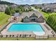 Aerial view of a large community pool, playground, and lounge chairs surrounded by lush greenery and neighborhood homes at 1136 Garner Creek Sw Dr, Lilburn, GA 30047