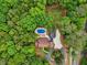 Breathtaking aerial view of an estate nestled among mature trees, featuring a pool and private driveway at 400 N Peachtree Pkwy, Peachtree City, GA 30269