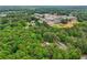 Aerial view of the property surrounded by lush greenery and featuring a nearby school and sports facilities at 400 N Peachtree Pkwy, Peachtree City, GA 30269