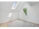 Well-lit attic features a window, skylight, and neutral carpet at 400 N Peachtree Pkwy, Peachtree City, GA 30269