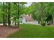 Scenic backyard view featuring a well-maintained lawn, mature trees, and a partial view of the home's exterior at 400 N Peachtree Pkwy, Peachtree City, GA 30269