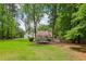 Expansive backyard with a well-maintained lawn, trampoline, and mature trees, perfect for outdoor activities at 400 N Peachtree Pkwy, Peachtree City, GA 30269