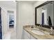 Bathroom features a granite countertop, dark framed mirror, and an adjacent bedroom at 400 N Peachtree Pkwy, Peachtree City, GA 30269