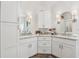 Bathroom vanity with double sinks, white cabinets, and complementary mirrors with sconces at 400 N Peachtree Pkwy, Peachtree City, GA 30269