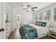 Cozy bedroom featuring a patterned duvet, multiple windows, and a ceiling fan at 400 N Peachtree Pkwy, Peachtree City, GA 30269