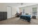 Bedroom with a ceiling fan, large window, two dressers, and neutral-colored carpet at 400 N Peachtree Pkwy, Peachtree City, GA 30269