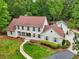 Charming two-story home with a brick walkway and lush landscaping, showcasing curb appeal at 400 N Peachtree Pkwy, Peachtree City, GA 30269
