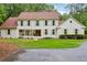 Inviting two-story traditional home with a covered front porch, manicured lawn, and tree-lined surroundings at 400 N Peachtree Pkwy, Peachtree City, GA 30269