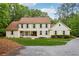 Inviting two-story home featuring a charming front porch and lush green lawn, blending classic elegance with serene nature at 400 N Peachtree Pkwy, Peachtree City, GA 30269