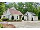 Charming white home with a spacious driveway and a detached garage, surrounded by lush greenery and mature trees at 400 N Peachtree Pkwy, Peachtree City, GA 30269