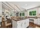 Open-concept kitchen with an island cooktop, views of the dining and living areas, and bright natural light at 400 N Peachtree Pkwy, Peachtree City, GA 30269