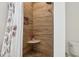 Stylish shower with wood-look tile, a built-in niche, and pebble stone flooring at 400 N Peachtree Pkwy, Peachtree City, GA 30269