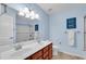 Bright bathroom with double sinks, a large mirror, and a shower with glass doors at 704 Woodbridge Dr, Woodstock, GA 30188