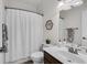 Neutral bathroom with a shower-tub combo, a dark wood vanity, and modern fixtures at 704 Woodbridge Dr, Woodstock, GA 30188