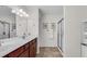The bathroom provides a double sink vanity, framed mirrors, and a large glass-enclosed shower at 704 Woodbridge Dr, Woodstock, GA 30188