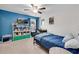 Bright bedroom with blue accent wall, shelving, and a comfortable bed with a blue comforter at 704 Woodbridge Dr, Woodstock, GA 30188