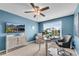Comfortable bedroom featuring a ceiling fan, a TV, and a desk with a rolling chair at 704 Woodbridge Dr, Woodstock, GA 30188