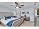The primary bedroom offers a ceiling fan, carpet, a large bed, and natural light from the window at 704 Woodbridge Dr, Woodstock, GA 30188