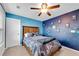 This themed bedroom showcases a ceiling fan, carpet, and a large bed with a themed wall at 704 Woodbridge Dr, Woodstock, GA 30188