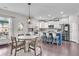 Open-concept kitchen and dining area with hardwood floors, stainless steel appliances, and a blue island at 704 Woodbridge Dr, Woodstock, GA 30188