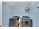 The laundry room offers a front load washer and dryer with shelf and decor at 704 Woodbridge Dr, Woodstock, GA 30188
