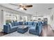 Bright living room features a large sectional sofa and a view of the kitchen at 704 Woodbridge Dr, Woodstock, GA 30188
