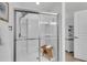 This tiled glass shower has a small wooden bench and shower caddy for storage at 704 Woodbridge Dr, Woodstock, GA 30188