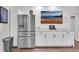 Convenient wet bar with stainless steel refrigerator, white cabinetry, and beach-themed artwork at 704 Woodbridge Dr, Woodstock, GA 30188