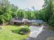 Aerial view of home, long driveway and covered parking, and lush green lawn surrounded by trees at 814 Clarke Trl, Dacula, GA 30019
