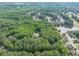 Lush green trees surrounding the home in this aerial view of the property with nearby houses and a pond at 814 Clarke Trl, Dacula, GA 30019