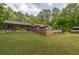 Expansive backyard featuring a covered outdoor living area, wooden deck, and lush greenery at 814 Clarke Trl, Dacula, GA 30019