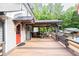 Home features a large deck with a covered area and a red door leading inside at 814 Clarke Trl, Dacula, GA 30019