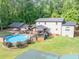 Home features above ground pool with patio, deck, carport, covered area and lush backyard with mature trees at 814 Clarke Trl, Dacula, GA 30019