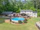 Expansive backyard features an above ground pool with decking, carport, patio, and beautiful landscaping at 814 Clarke Trl, Dacula, GA 30019