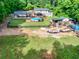 Aerial view of the backyard with a pool, covered patio, and extensive wooded area at 814 Clarke Trl, Dacula, GA 30019