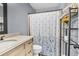 Bathroom featuring a single sink vanity with blue floral shower curtain and white toilet, creating a clean space at 814 Clarke Trl, Dacula, GA 30019