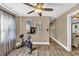 Bright exercise room with hardwood floors, a modern ceiling fan, and an exercise bicycle in the center of the room at 814 Clarke Trl, Dacula, GA 30019