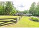 Spacious front yard with a charming fence, lush lawn, and a beautiful home in the background at 814 Clarke Trl, Dacula, GA 30019