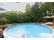 Inviting above ground pool, wooden deck, and patio furniture surrounded by lush greenery at 814 Clarke Trl, Dacula, GA 30019