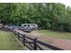 Property features equipment and storage area surrounded by a black fence and mature trees at 814 Clarke Trl, Dacula, GA 30019