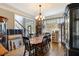 Dining room with wood floors, large chandelier, and large window with blinds at 1029 Laurel Grove Cts, Suwanee, GA 30024