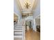 Bright foyer with hardwood floors, stairs and a decorative chandelier creating a grand entrance at 1029 Laurel Grove Cts, Suwanee, GA 30024