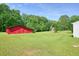 Spacious, green backyard showing the outbuilding perfect for storage or hobbies at 110 Barnesdale Ter, Woodstock, GA 30188