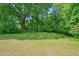 A large grass yard is surrounded by mature trees and shrubbery at 110 Barnesdale Ter, Woodstock, GA 30188