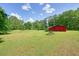 A well-manicured lawn features a red barn-like structure in the background at 110 Barnesdale Ter, Woodstock, GA 30188