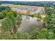 Aerial view of a new construction neighborhood, with a lake surrounded by trees and new homes at 3462 Fishpond Cir, Dacula, GA 30019