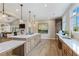 Large island with bar seating and pendant lights highlighting the stainless steel appliances and marble backsplash at 3462 Fishpond Cir, Dacula, GA 30019