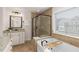 Relaxing bathroom featuring a soaking tub, a separate glass-enclosed shower, and wood-look ceramic tile at 3585 Adelaide Xing, Brookhaven, GA 30319
