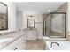 Primary bath featuring granite-topped vanity, soaking tub and glass enclosed shower at 3585 Adelaide Xing, Brookhaven, GA 30319