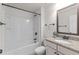 This bathroom has a granite countertop, framed mirror, and shower-tub combo at 3585 Adelaide Xing, Brookhaven, GA 30319